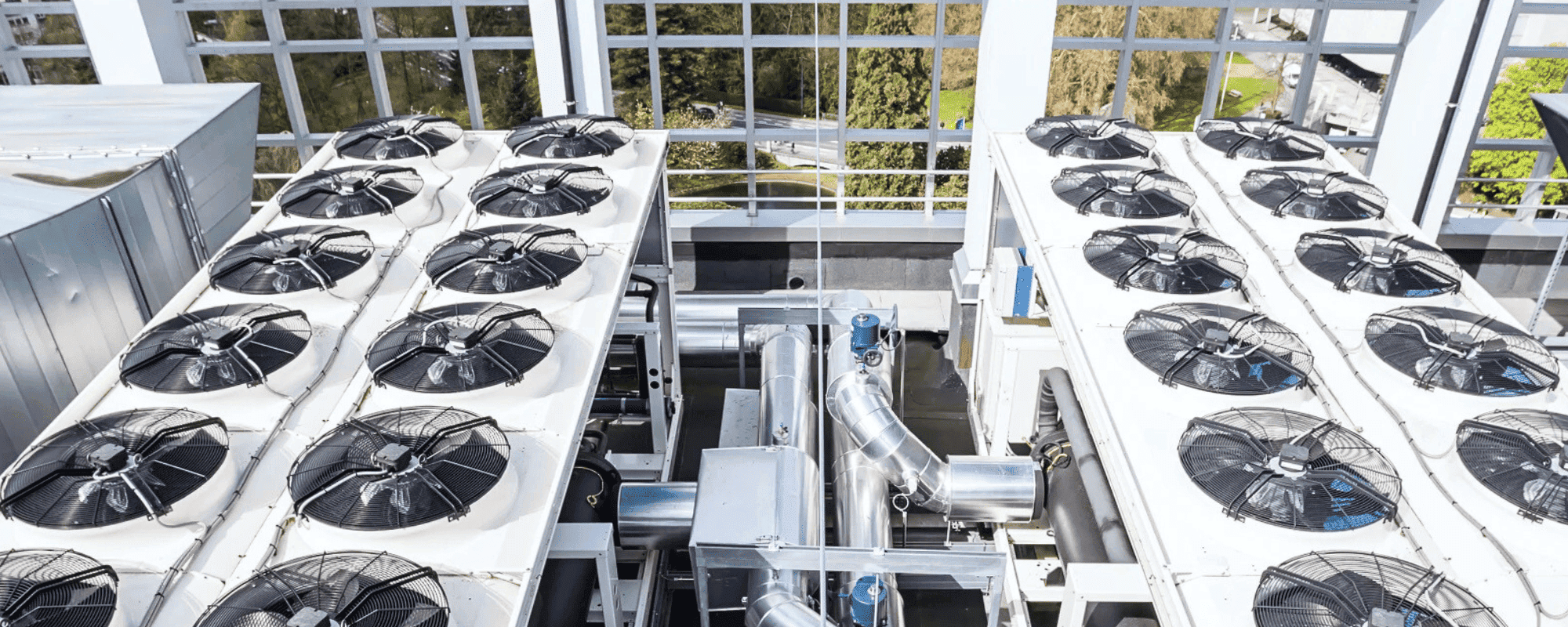 Heavy-duty commercial HVAC installation services showing large industrial rooftop chiller units and mechanical ventilation piping setup by Pujnik in Delhi.