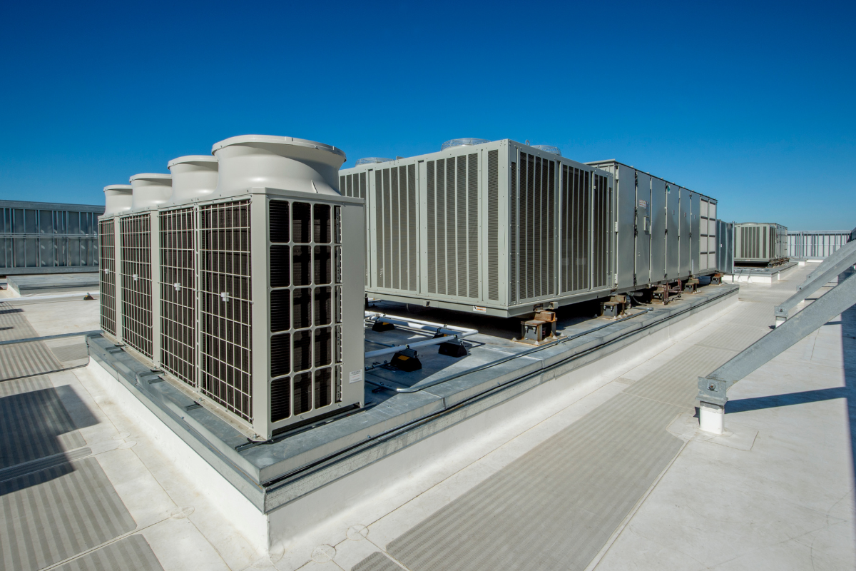 Industrial VRF outdoor units and large air handling unit modules installed on a commercial building rooftop by Pujnik.