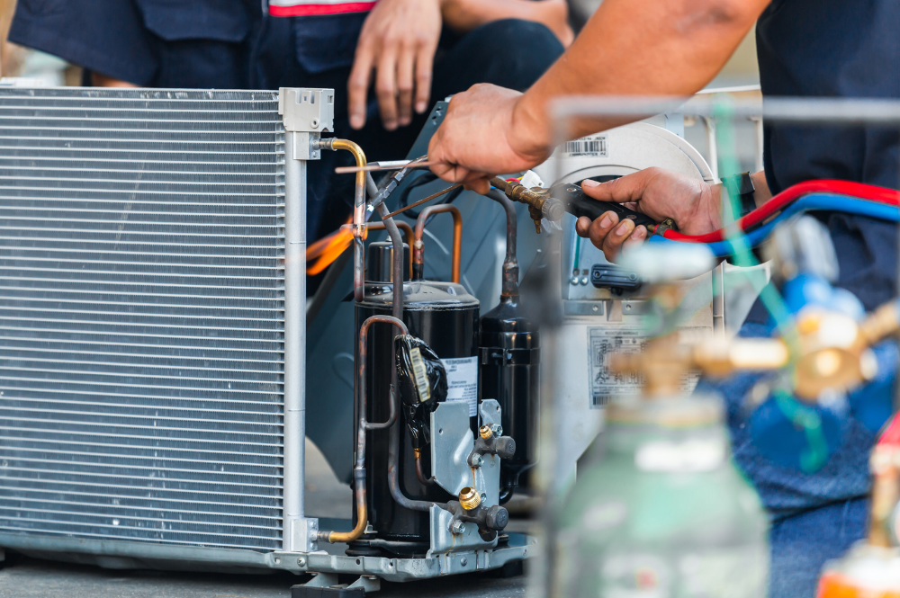 A technician welding air conditioner compressor parts, showing the field expertise of leading hvac contractors in delhi like Pujnik