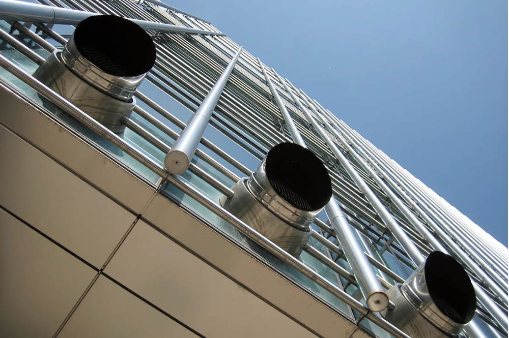 Large external air exhaust vents installed on a modern corporate skyscraper by a premier hvac company in delhi like Pujnik